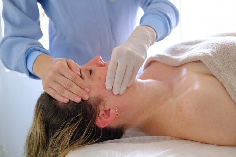 Fisioterapeuta realizando abordagem intraoral, com luvas, nos principais músculos mastigatórios da paciente